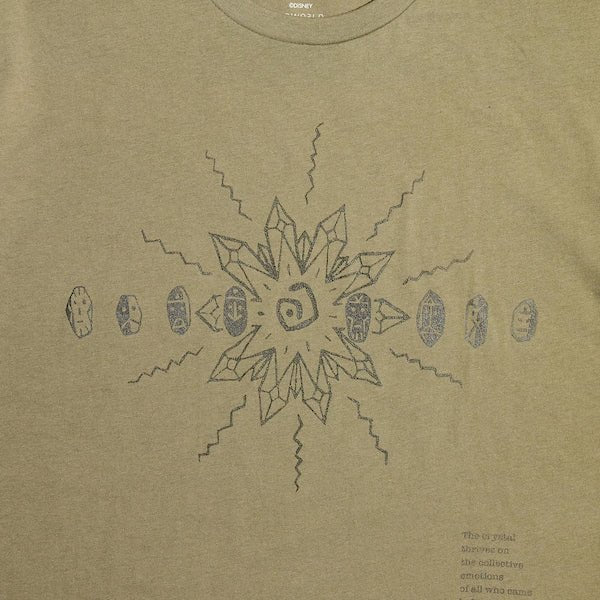 Green T-shirt with a dark blue abstract sunburst design and text in the bottom right corner.
