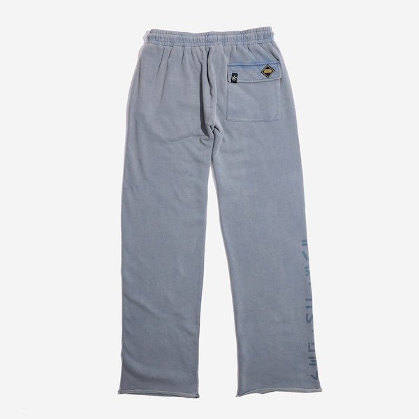 The back of blue sweatpants with an elastic waistband, featuring a back pocket with button closure and a vertical "Jedi Knights" graphic printed in distressed black text along the lower left leg.