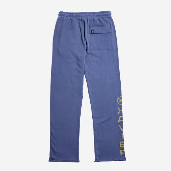 The back of blue sweatpants with an elastic waistband, featuring a back pocket with button closure and a vertical "Xavier" graphic printed in distressed yellow text along the lower left leg.