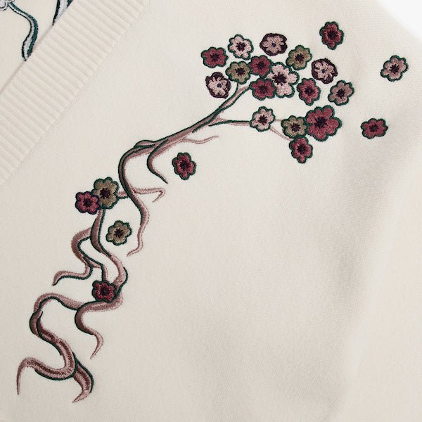 Close up of a white cardigan showing embroidered Cherry Blossoms