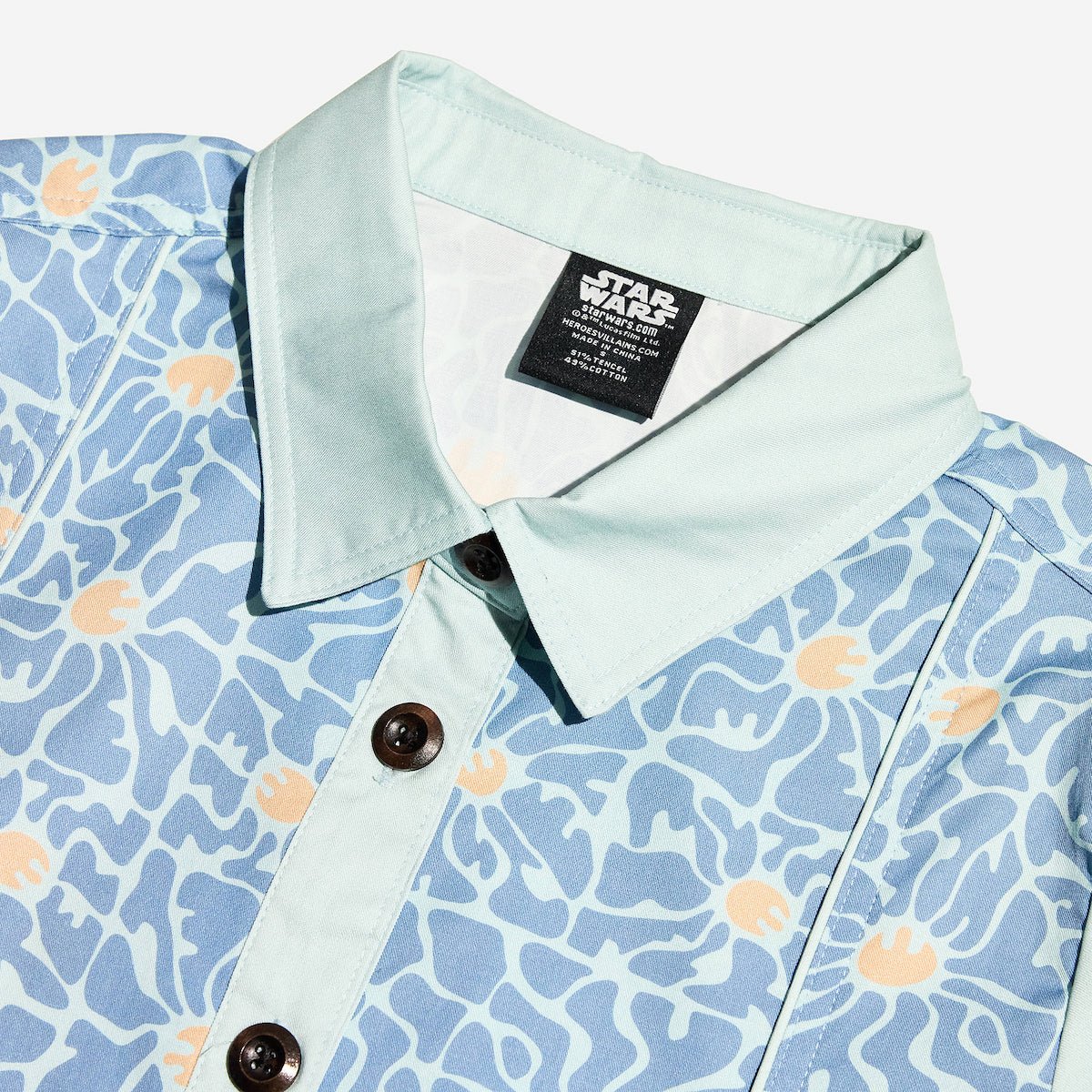 Close up of a blue star wars rebel dress with 60s inspired patterns. The photo focuses on the collar detail and buttons.