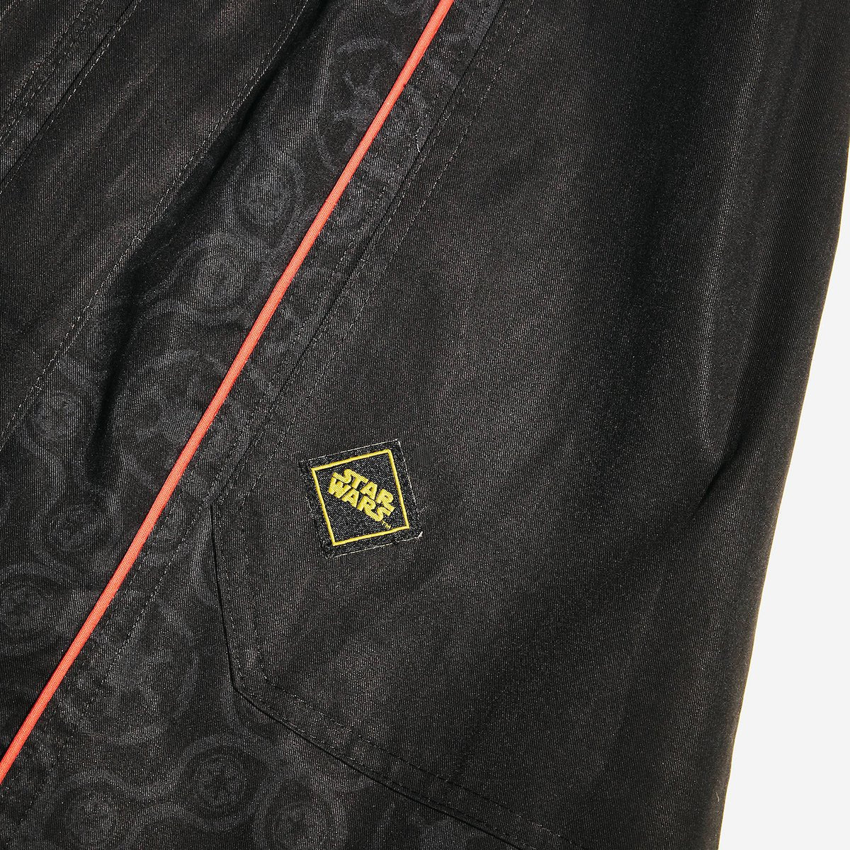 Close up of a button up black dress thats star wars imperial inspired with a geometric pattern and red details
