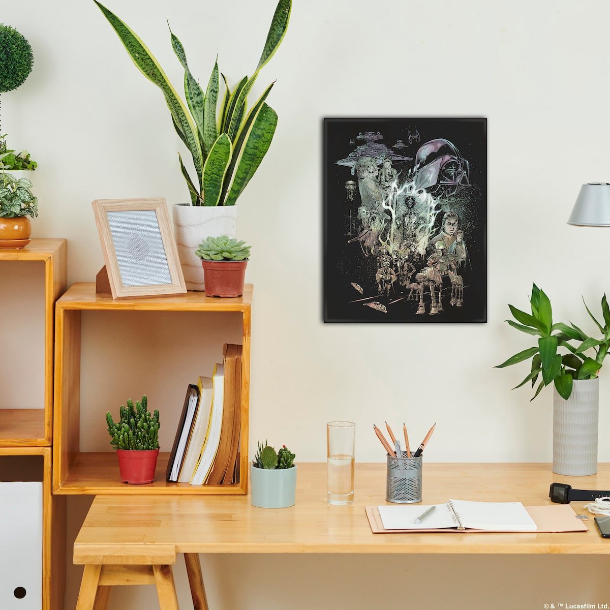 Home office setup with a desk, plants, and canvas artwork on the wall.
