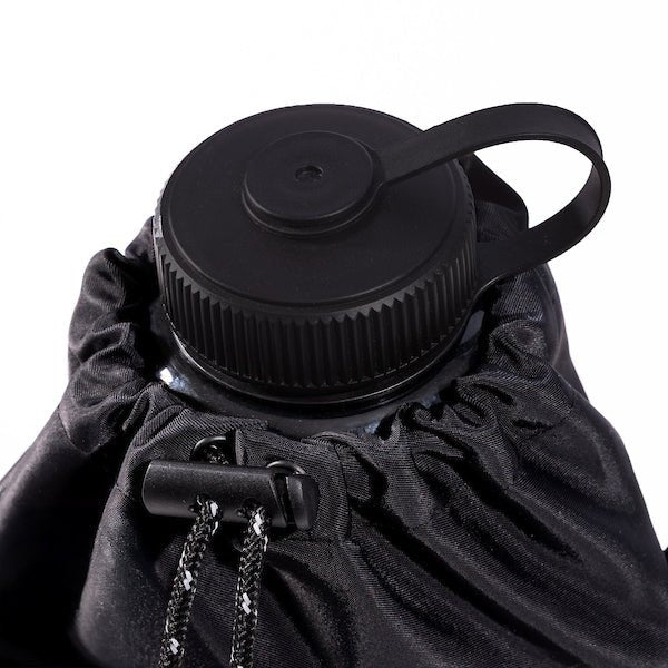 The photo shows a close up of a water bottle inside of a bag. The bags draw string is tight around the neck of the water bottle so only the lid is exposed