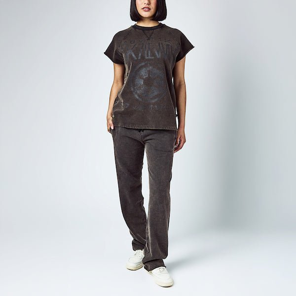 A woman dressed in a black sleeveless crew neck and black wide leg sweatpants, featuring a Star Wars Empire themed lounge set