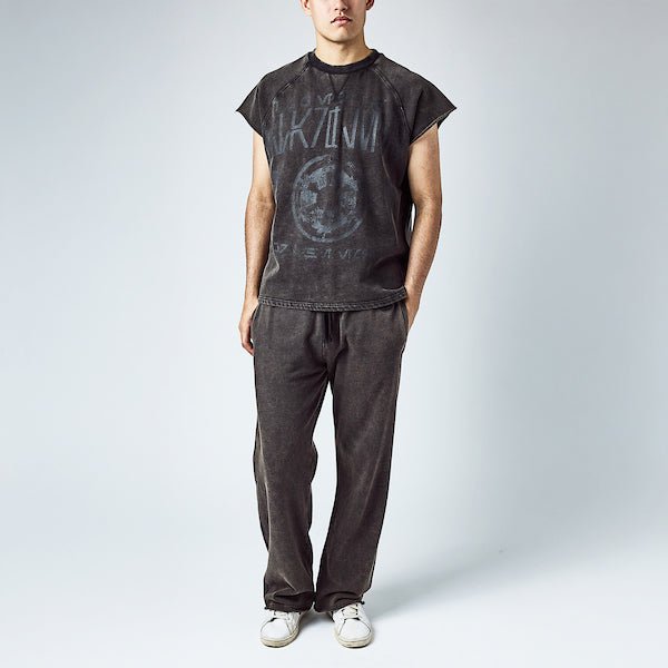 A man dressed in a black sleeveless crew neck and black wide leg sweatpants, featuring a Star Wars Empire themed lounge set