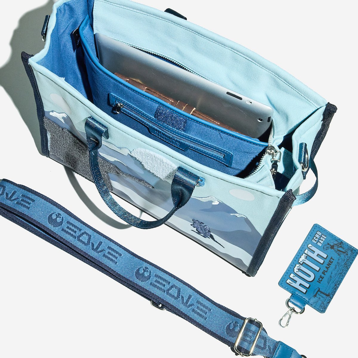 Blue bag with interior details and a matching strap on a white background