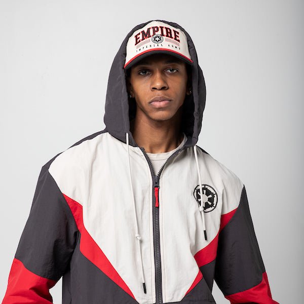 A man in a Star Wars-themed hooded windbreaker jacket and hat. The jacket features an Imperial Army emblem on the left chest. The jacket has a color-blocked design in Black, White and Red, with a front zipper, adjustable drawstrings on the hood, elastic cuffs, and two zippered pockets.