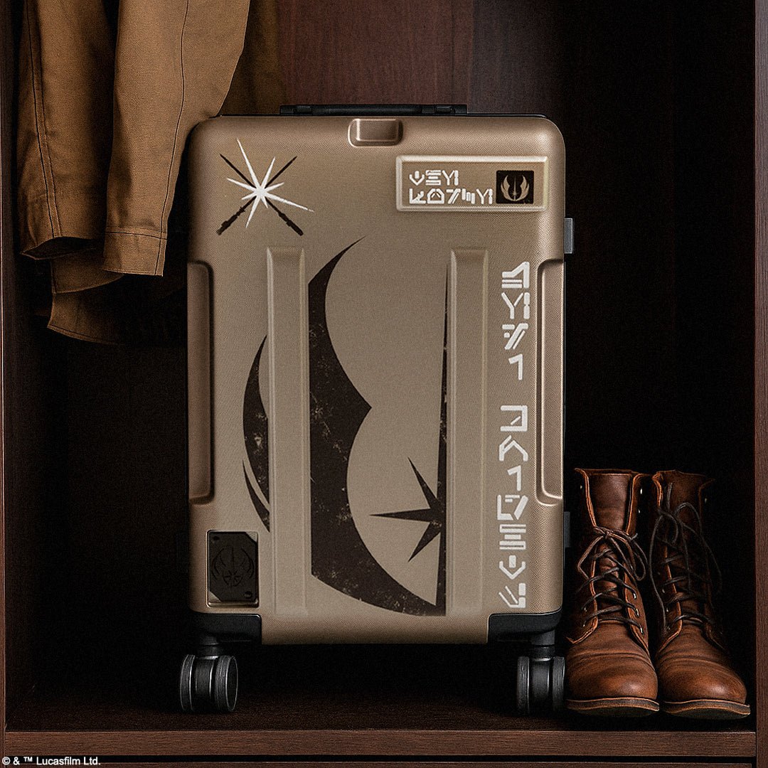 Brown suitcase with Jedi design and text, placed on a dark surface with brown boots and jacket.