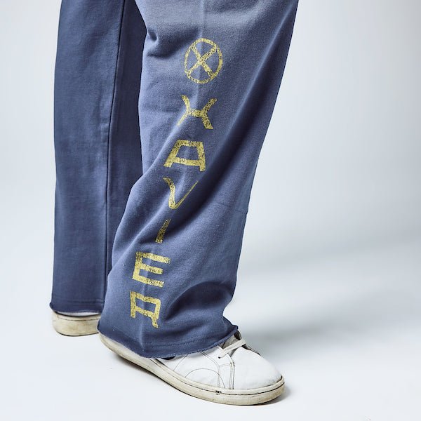 Close up detail of sweatpants. The leg has "Xavier" in yellow text down the leg