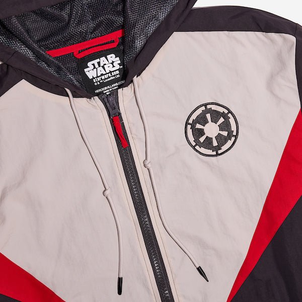 A close up of a Star Wars-themed hooded windbreaker jacket featuring a Imperial Army emblem on the left chest. The jacket has a color-blocked design in Black, White and Red, with a front zipper, adjustable drawstrings on the hood