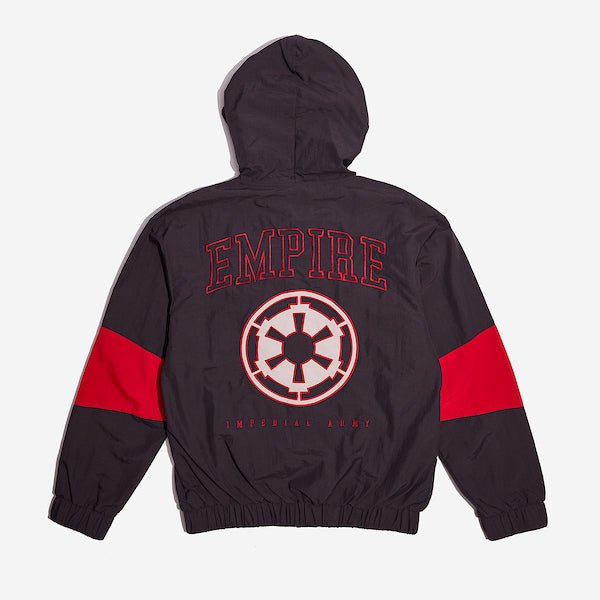The back of a Star Wars-themed hooded windbreaker jacket, primarily black with red and white accents. The design features large, bold text reading 'Empire' across the upper back, with the Imperial Army emblem in white with a red boarder it. Beneath the emblem, the words 'Imperial Army' are printed in a smaller font. The jacket has an elastic waistband and cuffs, with a color-blocked pattern matching the front design.