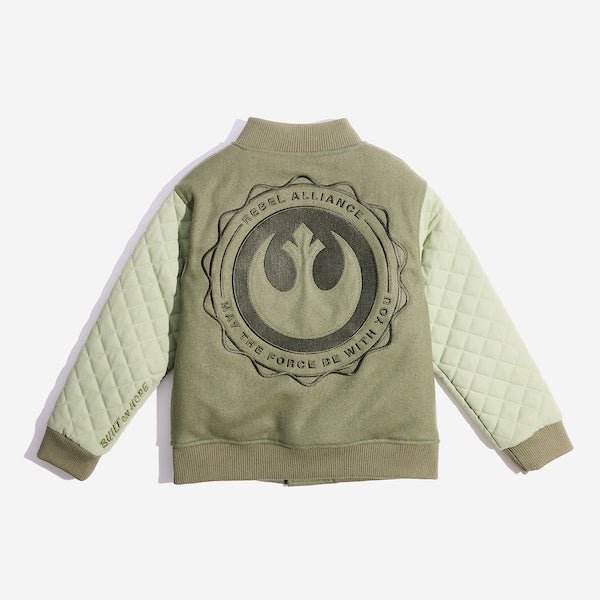 The back of an olive green varsity-style jacket with quilted light green sleeves. The body of the jacket is made of a soft, solid fabric, while the sleeves have a diamond-quilted pattern. It features a ribbed collar, cuffs, and hem. There is a large circular embroidery featuring the Star Wars Rebel emblem. There is text that says "Rebel Alliance" at the top and "May the force be with you" at the bottom in a circular shape around the rebel emblem.