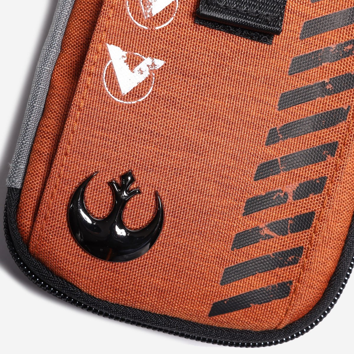 Close-up of an orange pouch with a black Star Wars Rebel emblem on a white background