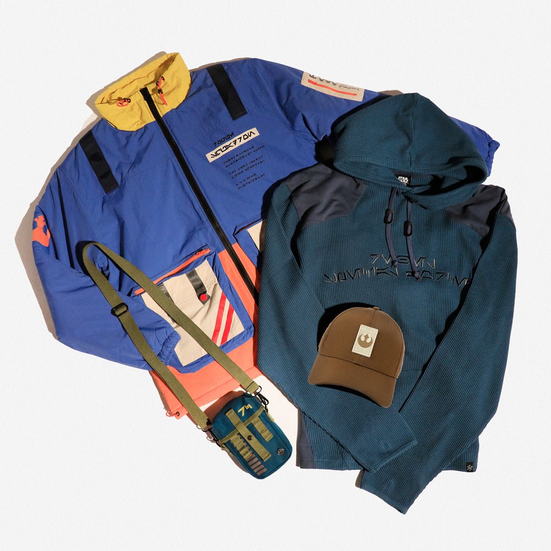 Blue jacket, green hoodie, and brown cap on a white background