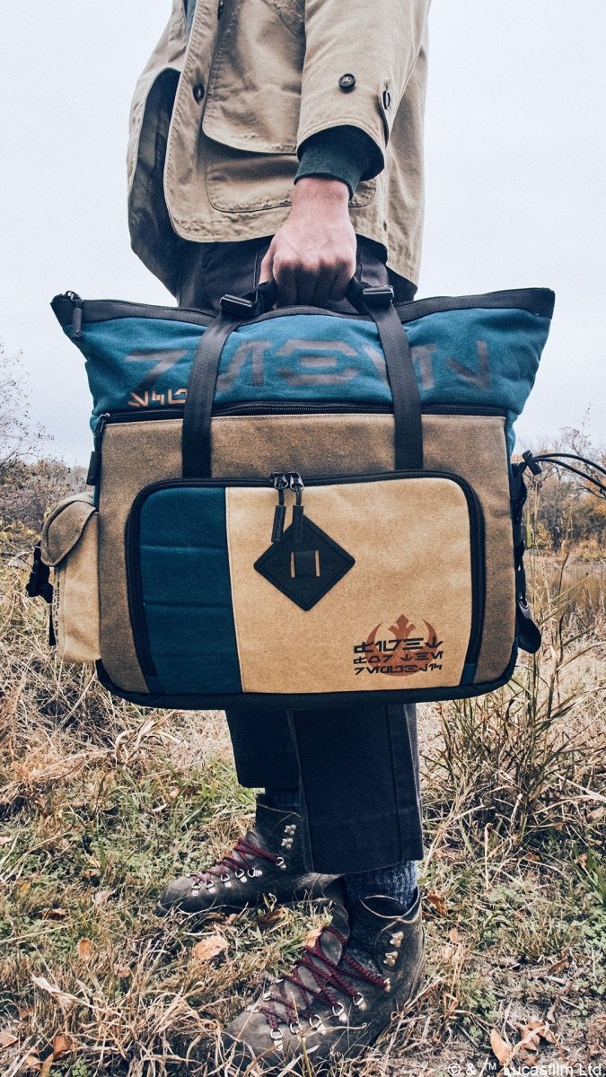 Close-up of a man carrying the Heroes & Villains Rebel Teal Commuter Bag in a nature scene.