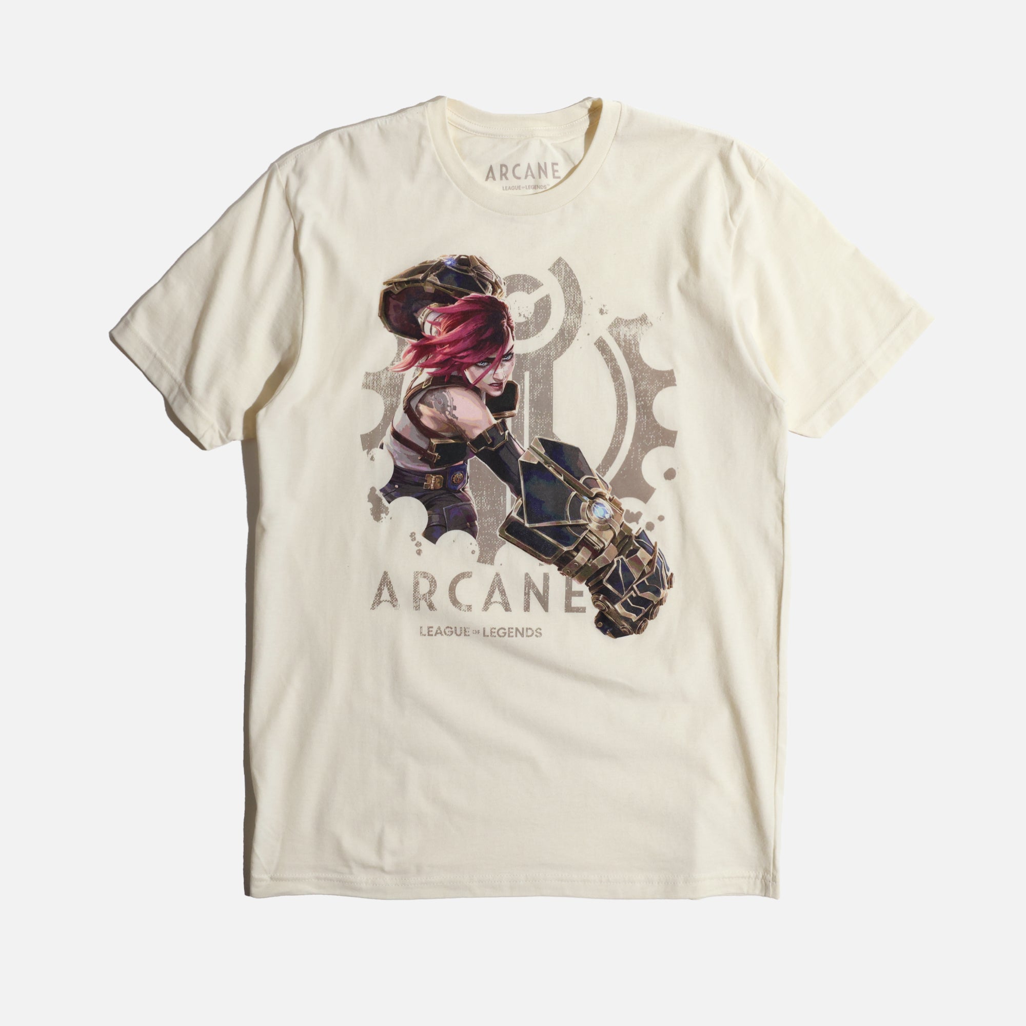 A cream-colored Arcane x League of Legends t-shirt featuring Vi in an action pose. She has her signature pink hair and wields her massive Hextech gauntlets, detailed with metallic and glowing blue accents. Behind her, a faded Piltover gear emblem adds depth to the design. 'Arcane' and 'League of Legends' are printed below in a bold, distressed font