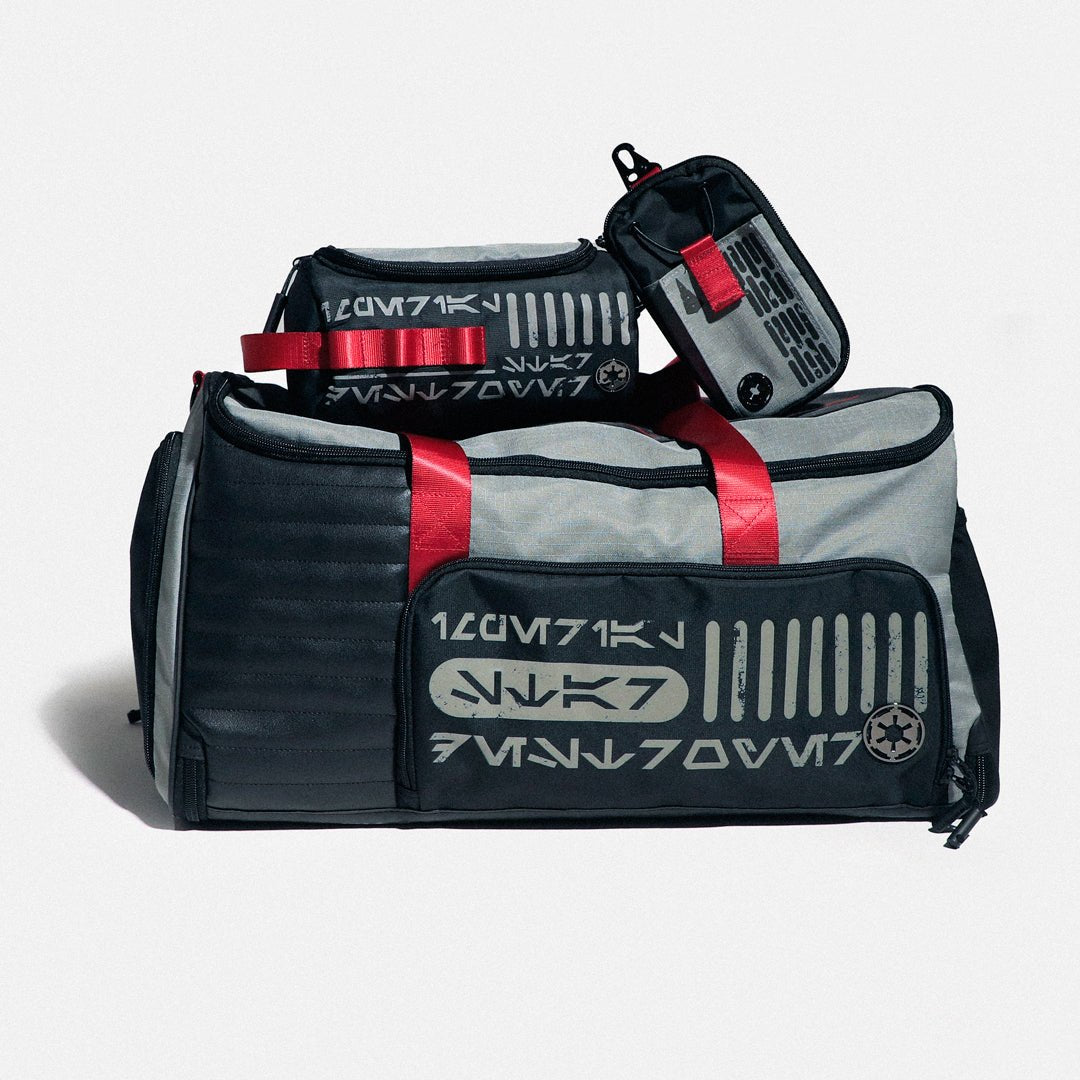 Two duffel bags with red straps and visible branding on a light gray background