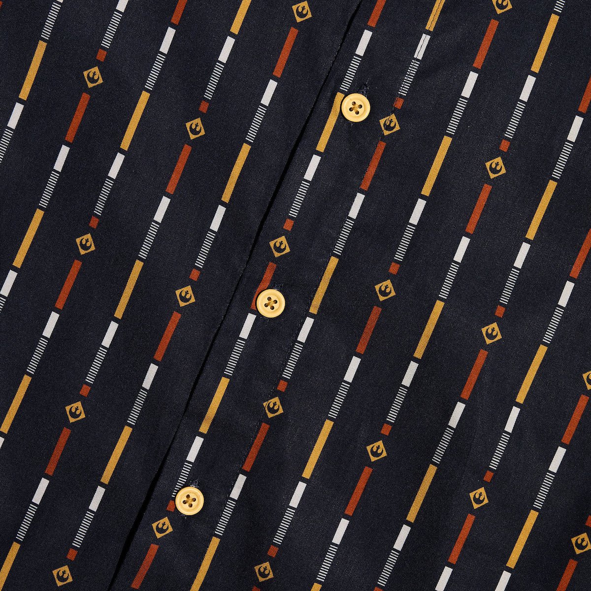 A close up of a button up navy shirt with a star wars rebel motif in a striped pattern