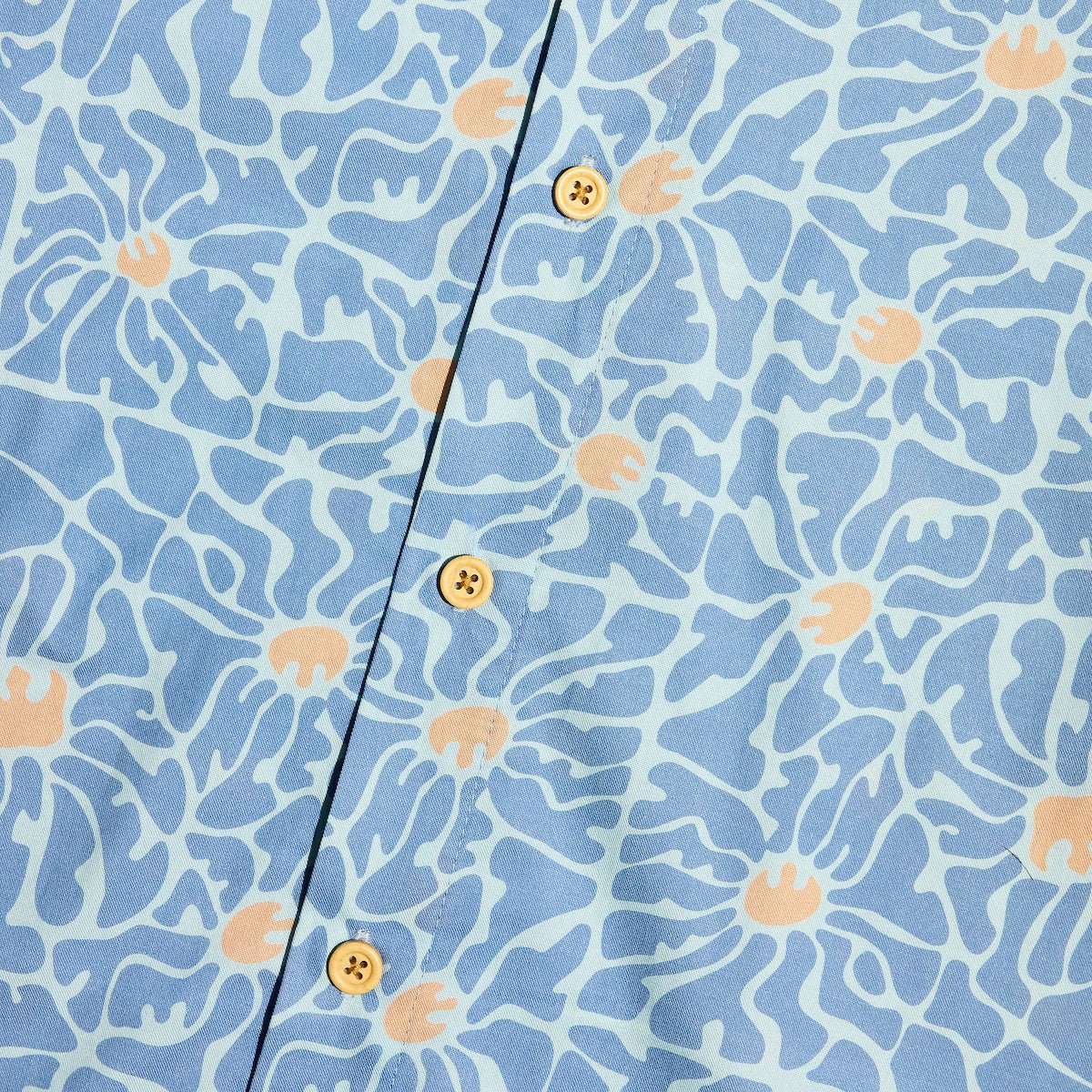 A close up of a blue button down star wars rebel shirt with 60s inspired patterns