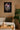 Living room with a canvas on the wall, a couch, and a plant.