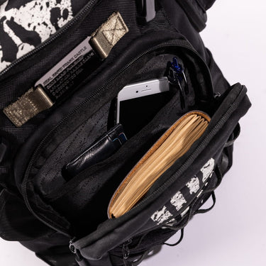 Detail shot of The Punisher Trekker Backpack showing front zipper opened with compartments holding items