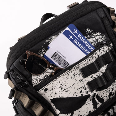 Detail shot of Black The Punisher backpack showing top front pocket holding sunglasses and boarding passes
