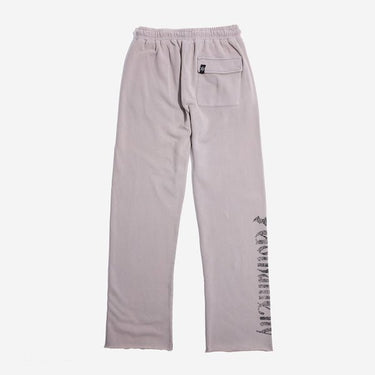 The back of light grey sweatpants with an elastic waistband, featuring a back pocket with button closure and a vertical "Gotham City" graphic printed in distressed black text along the lower left leg.