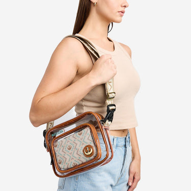 Woman carrying a clear rebel crossbody bag with a patterned front pocket on a white background