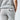 Close up of a person wearing light grey sweatpants with a back pocket