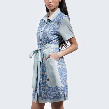 Woman standing sideways in a blue star wars rebel dress with 60s inspired patterns