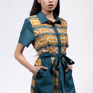 A woman in a button up yellow and teal dress thats star wars jedi inspired with a striped tapestry pattern 