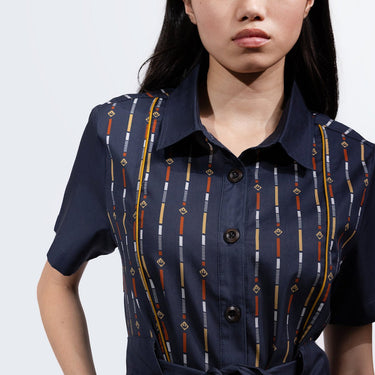 A close up of a woman in a button up navy dress thats star wars rebel inspired with a striped pattern 