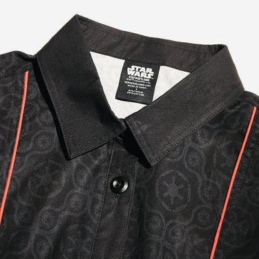 Close up of a button up black dress thats star wars imperial inspired with a geometric pattern and red details