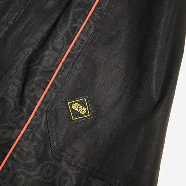 Close up of a button up black dress thats star wars imperial inspired with a geometric pattern and red details