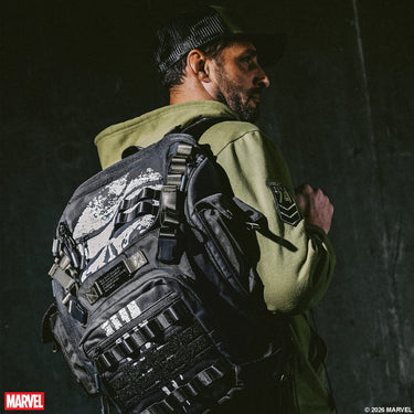 Person wearing a tactical The Punisher backpack with Marvel branding on a dark background