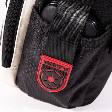 The photo shows a close up of a pocket on the bag. The pouch has a black strap with Red rubber on the end. The Red Rubber has raised black art to showcase the Imperial logo. 