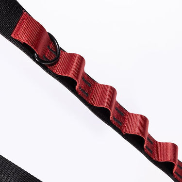 The photo shows a close up detailing of the shoulder strap. Featured is the Red decorative detailing. The detailing has loops for attaching clips and a tech case. The top loop has a "D"-Ring attached.