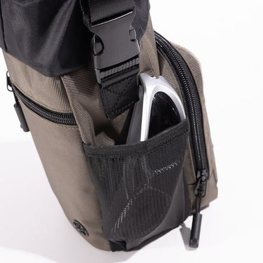 The photo shows a close up of a mesh pocket on the side of the bag. The mesh pocket is holding a pair of white sunglasses.