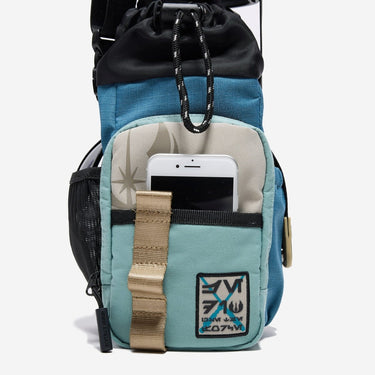 The photo shows a close up of the bags main outer zipper pouch. The pouch has an star wars jedi patch on the bottom right and an jedi logo printed on the top left. There is a pocket on this pouch showing an iphone being held. 