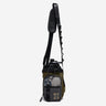 The photo shows a crossbody bag designed for carrying a water bottle. The bag features a drawstring closure at the top, a front zippered pocket, and black molle loop strap meant for attaching a clip. The adjustable black strap has a padded section for comfort and a brown molle loop strap to attach clips and a tech organizer bag (Not pictured). The bag is in a subtle brown with pops of grey and beige