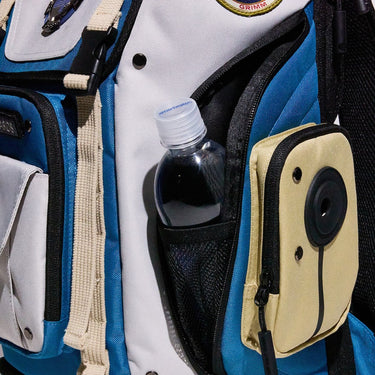 Close-up of a backpack with a water bottle and small pouches.