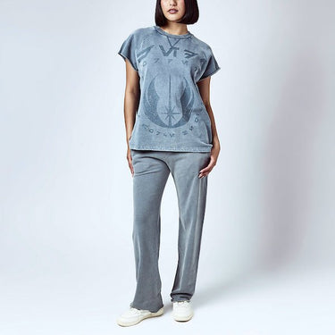 A woman dressed in a blue sleeveless crew neck and blue wide leg sweatpants, featuring a Star Wars Jedi themed lounge set