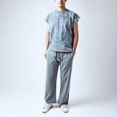 A man dressed in a blue sleeveless crew neck and blue wide leg sweatpants, featuring a Star Wars Jedi themed lounge set