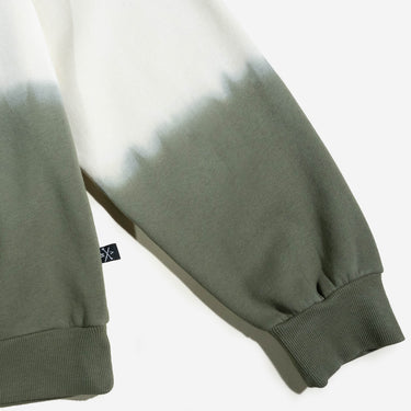 A dip-dyed hoodie in cream and green featuring X-Men's Rogue and Gambit. The front displays a small X-Men logo, while the back showcases a black-and-white comic-style illustration of Rogue and Gambit embracing, with the word "Sugah" below.