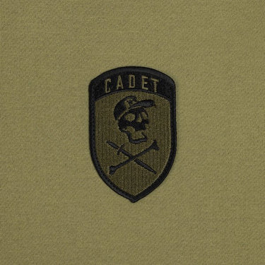 The photo shows up-close detail of the patch on the green hoodie. The patch is military style with the word "Cadet" at the top and a Skull and cross bones underneath. The Skull is wearing a hat!