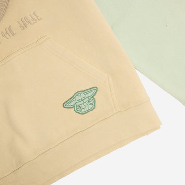 beige and tan hoodie with small grogu from star wars embroidered on a kangaroo pocket