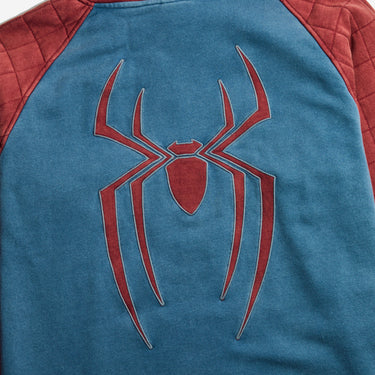 Close-up of a Spider-Man themed raglan shirt showing the back, with a large red spider logo on a blue fabric body and red quilted sleeves.