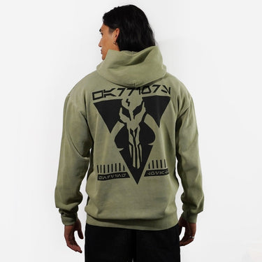 Person wearing a Green hoodie with a Warriors of Mandalore logo on the backt against a white background