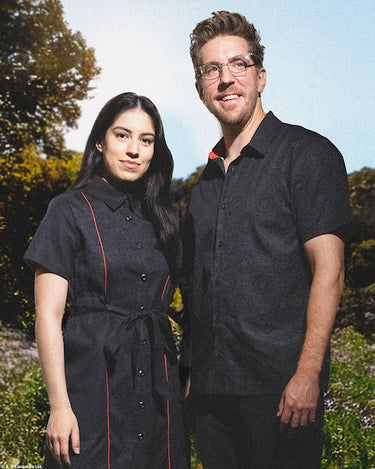 Couples standing in a park wearing a star wars themed imperial button up shirt and matching button up dress